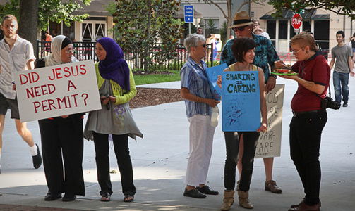 Local community supports Food Not Bombs Community holds up banners